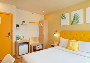 Een hotelkamer met een bed, een bureau, een minibar, een kledingkast en een badkamer.