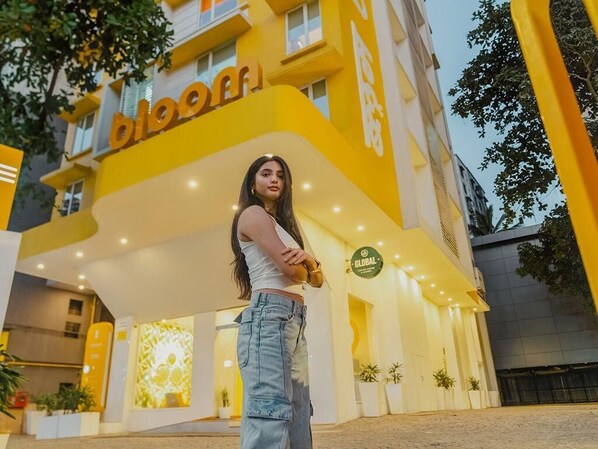 A hotel entrance with a yellow facade and a sign that reads 'bloomfi'. - Bloom Hotel - Saki Vihar Powai (Mumbai)