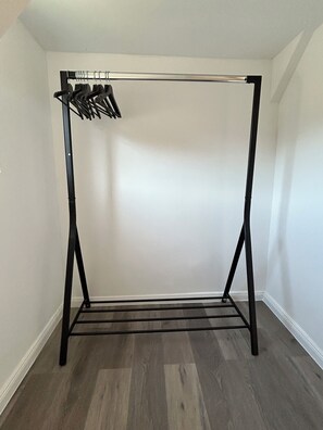A room with a black metal wardrobe stand and a wooden floor. - Spacious and modern apartment, centrally located and quiet (Ennepetal)