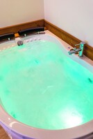 Una bañera con un grifo y una llave de control.
