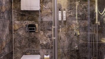 Un baño moderno con ducha de vidrio, inodoro y barra para toallas.
