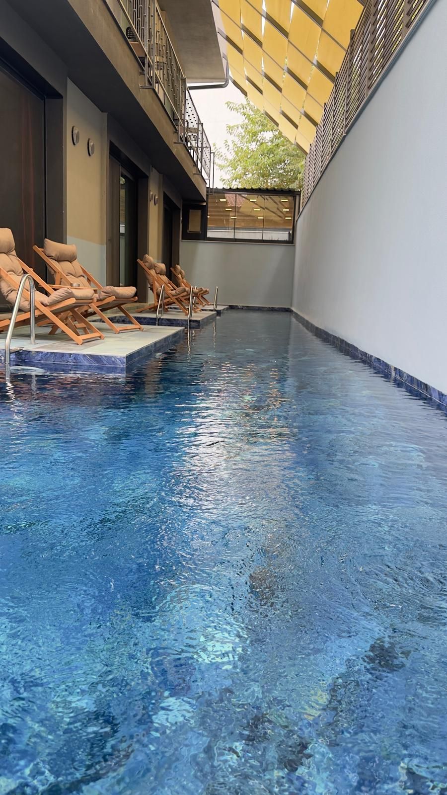 Una piscina interior con sillones de descanso y una zona cubierta.
