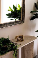 Um banheiro com espelho, pia e um pequeno objeto decorativo no balcão.