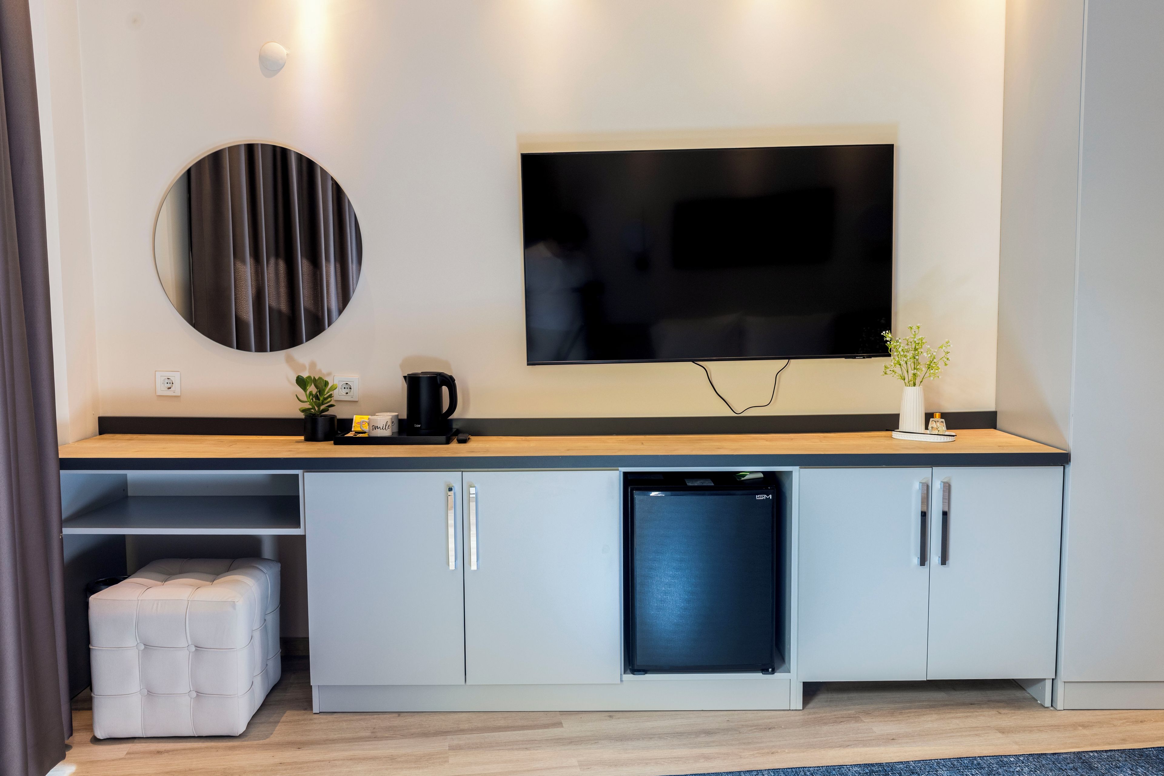 Una cocina moderna con lavavajillas integrado, cafetera y televisor de pantalla plana montado en la pared.