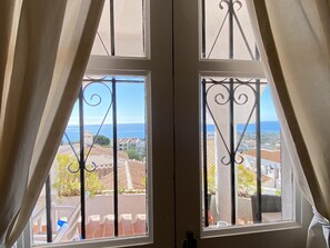 A window with a view of a coastal town and the sea. - Apartment in Nerja With Sea Views & Pool (Nerja)