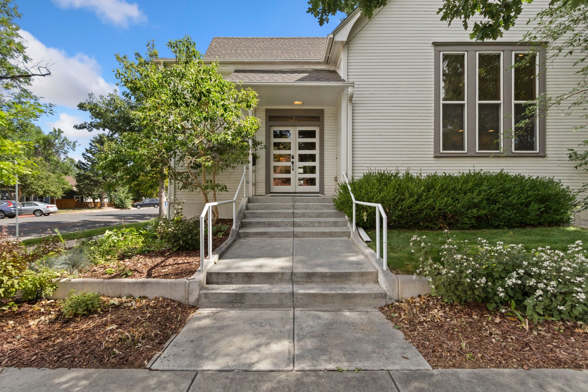 A two-story house with a front porch, a driveway, and a well-maintained lawn.