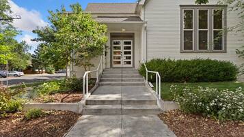 A two-story house with a front porch, a driveway, and a well-maintained lawn.