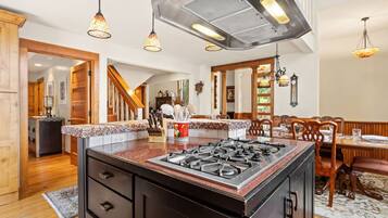 A spacious kitchen with a central island, wooden cabinetry, and a gas stove.