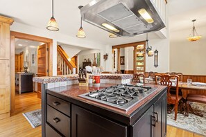 Cozinha espaçosa com ilha central, armários de madeira e fogão a gás.