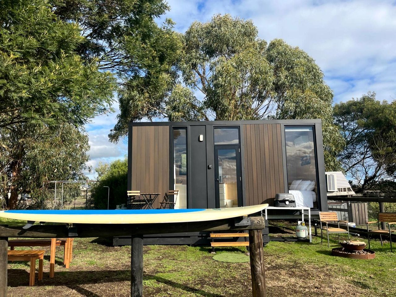 A modern, compact cabin with a visible sleeping area and a dining setup.