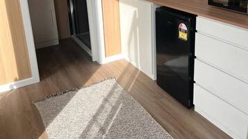 Cocina compacta con refrigerador, microondas y lavamanos.
