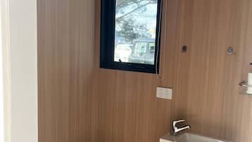Een kleine badkamer met toilet, wastafel en raam.