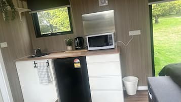 A compact kitchenette with a microwave, a small refrigerator, and a sink.