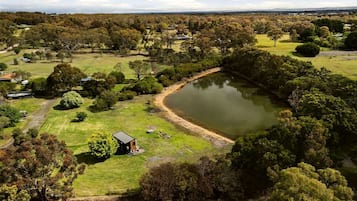 A large body of water surrounded by trees and a small building.