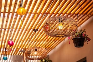 Techo de listones de madera con lámparas de mimbre colgantes.