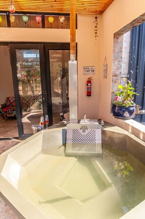 A spa area with a hot tub, a fire extinguisher, and a potted plant.