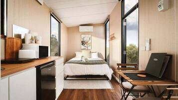A modern bedroom with a bed, bedside table, and a desk with a chair.