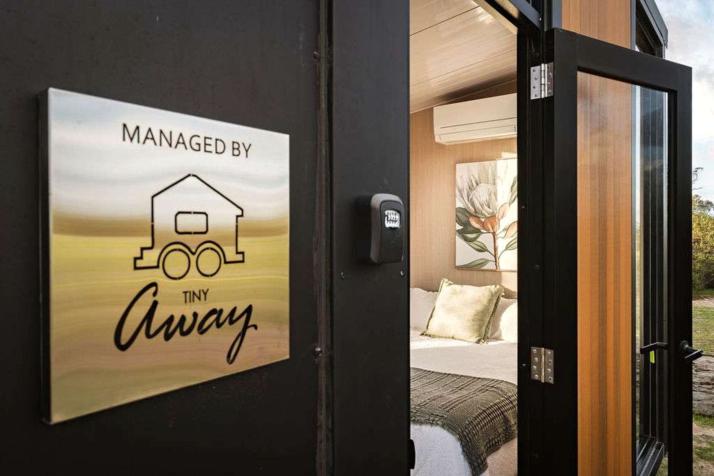 A door with a sign indicating the property is managed by Tiny Away.