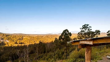A lookout signpost with a view of a forested landscape.