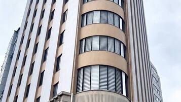 A tall, curved hotel building with multiple floors and large windows.