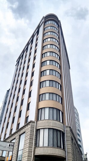 A tall, curved hotel building with multiple floors and large windows. - Dooka Apartment (Addis Ababa)