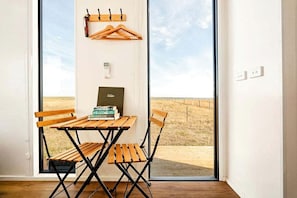 A room with a wooden table and chairs, a coat rack, and a bookshelf with books.