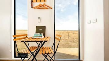 A room with a wooden table and chairs, a coat rack, and a bookshelf with books.