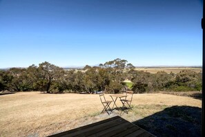 An outdoor seating area with a view of a rural landscape. - Marvelous Glamping Getaway for Two: Secluded and Tranquil Tiny House in Ararat, Victoria (Ararat)