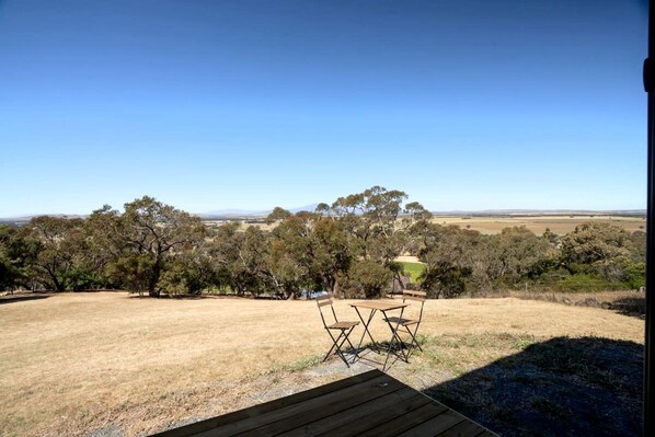 An outdoor seating area with a view of a rural landscape.
