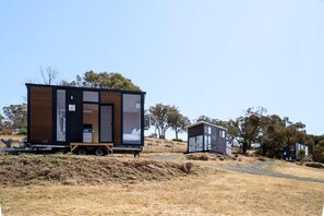 Uma casa móvel moderna com um quarto, uma cozinha compacta e uma sala de estar.