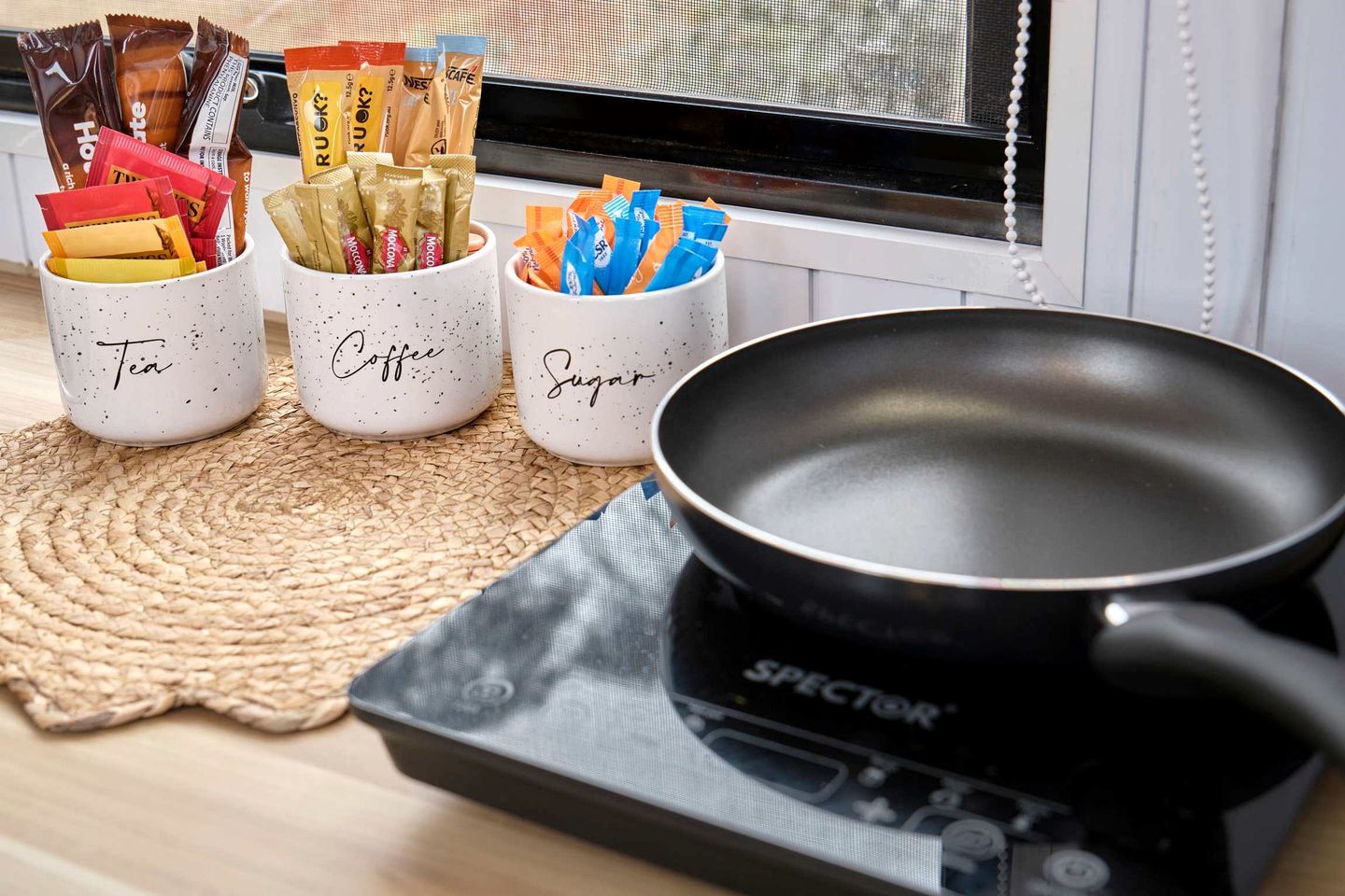 Three labeled containers with snacks and a black pan on a stove.