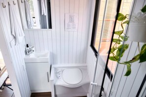 A compact bathroom with a toilet, sink, and towel rack.