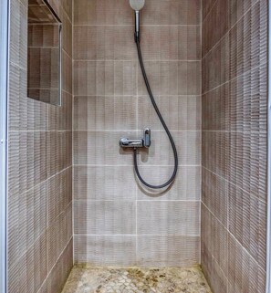A shower with a handheld showerhead and a flexible hose.
