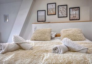 Une chambre à coucher avec un lit, des oreillers et une tête de lit.