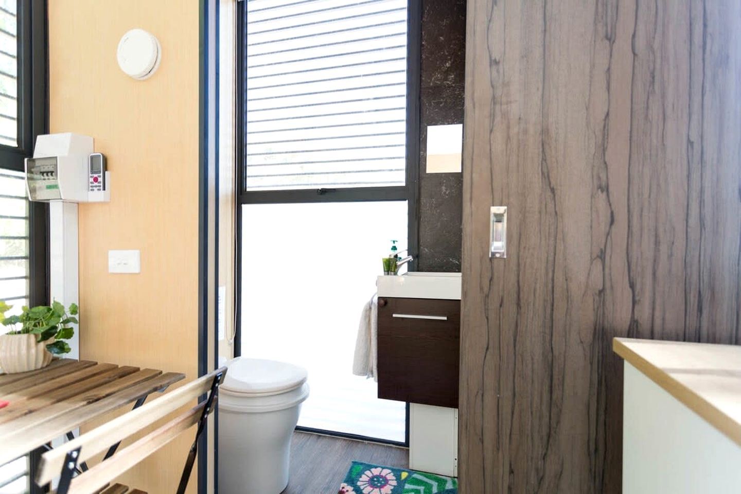 A compact bathroom with a toilet, sink, and a small window.