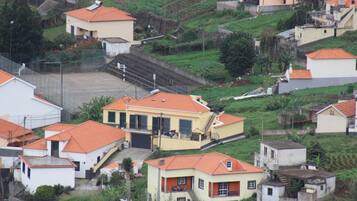 Zona residencial com casas de telhado vermelho e um edifício central com garagem e escadaria.