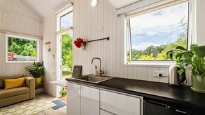 A compact kitchen with a sink, a countertop, and a view of greenery outside. - The Perch in Korweinguboora, Victoria (Korweinguboora)