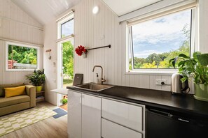 A compact kitchen with a sink, a countertop, and a view of greenery outside. - The Perch in Korweinguboora, Victoria (Korweinguboora)
