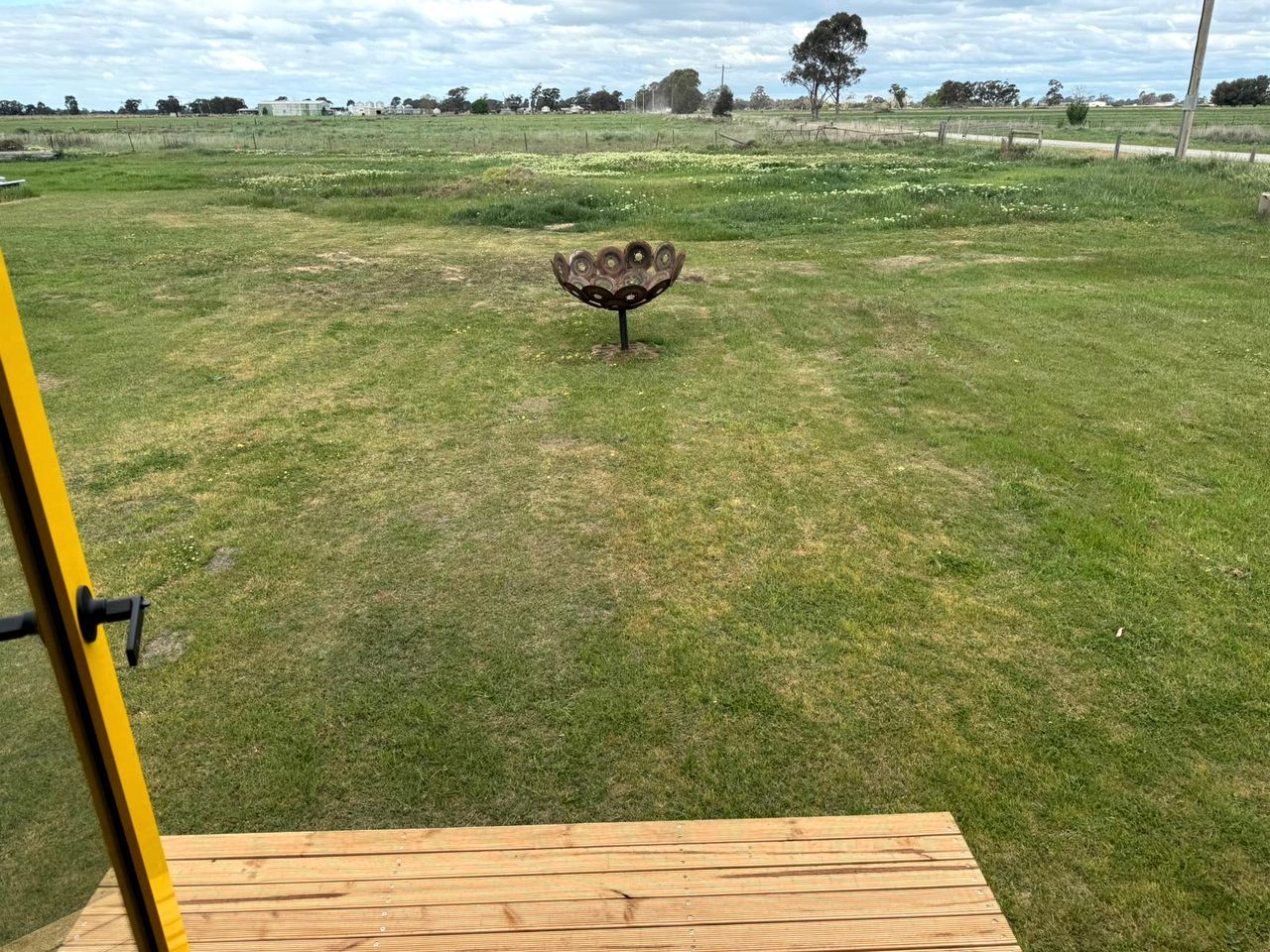 A grassy field with a metal sculpture in the center.