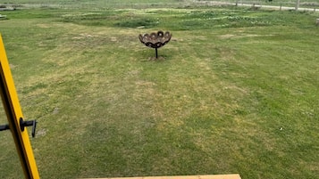 Un campo cubierto de césped con una escultura metálica en el centro.