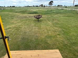 Un campo cubierto de césped con una escultura metálica en el centro.