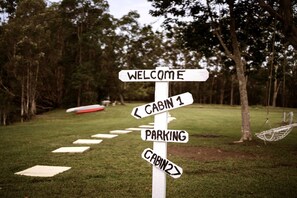 A directional signpost with arrows pointing to 'Welcome,' 'Cabin 1,' 'Parking,' and 'Cabin 2.' - Breathtaking Tiny House Close to Great Hiking Trails in Coffs Harbour, New South Wales (Coffs Harbour)