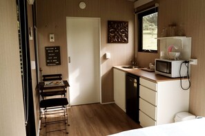 Une petite cuisine équipée comprenant un four à micro-ondes, un évier et un petit plan de travail.