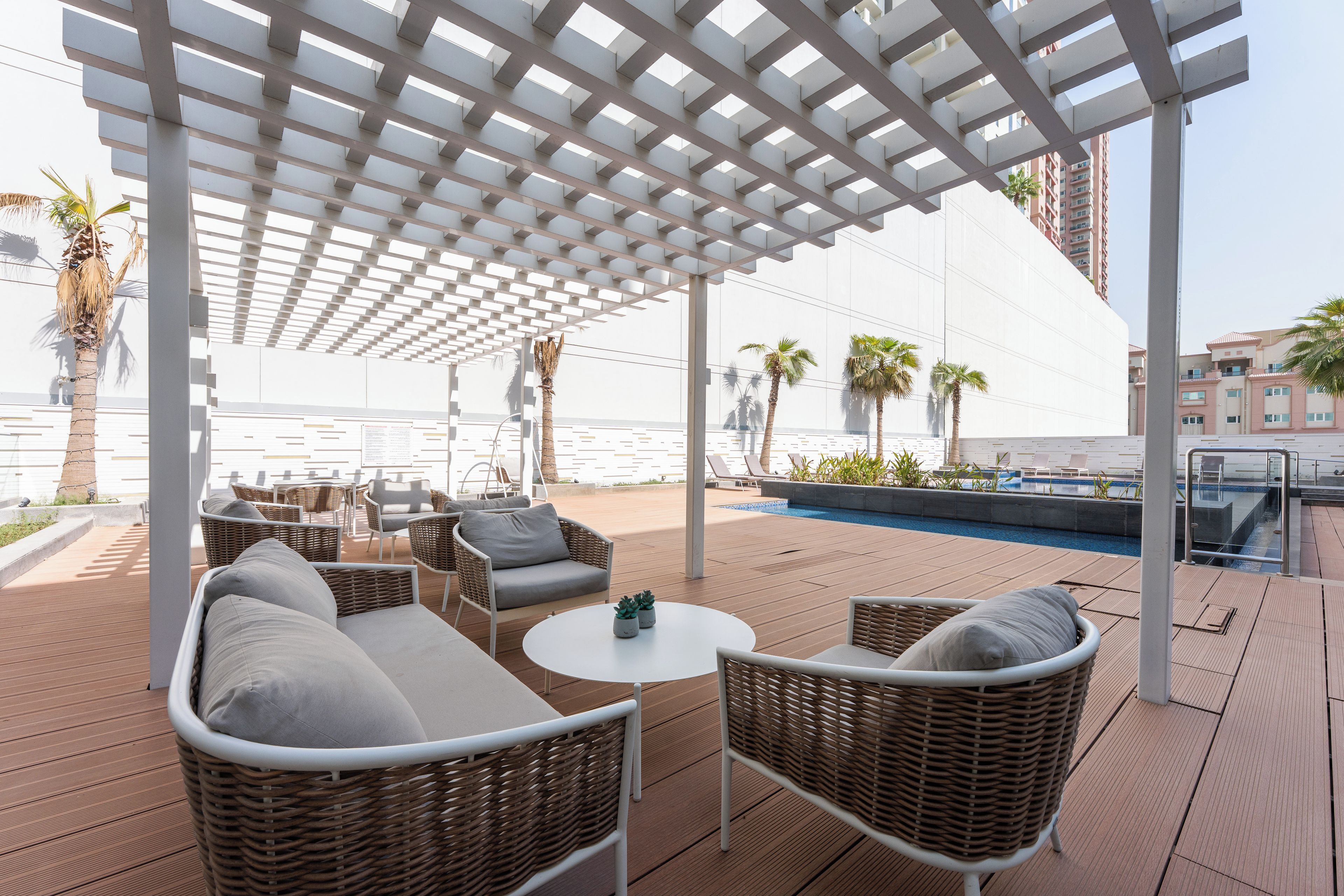 A rooftop terrace with outdoor seating, a pool, and a view of the city skyline.