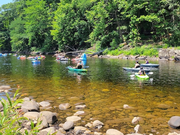 Un río con aguas transparentes, rodeado de rocas y vegetación.