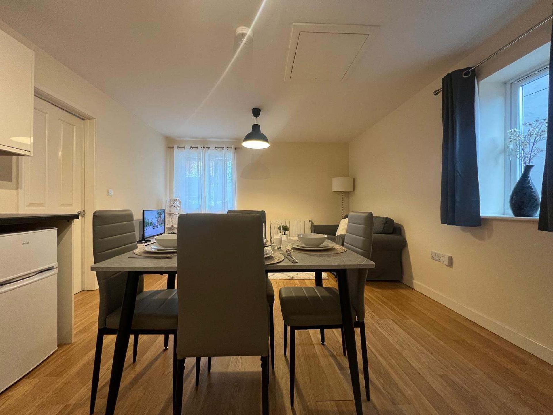 Un espacio habitable compacto con comedor, kitchenette y sofá.