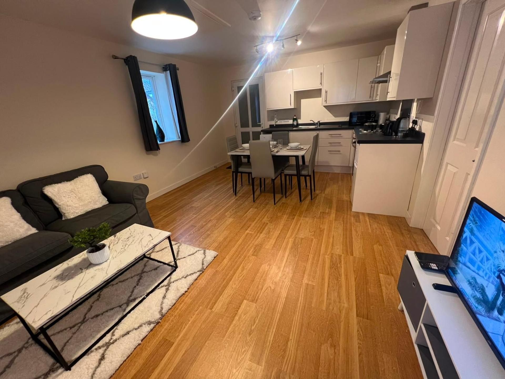 A compact living space with a sofa, dining table, and kitchenette.