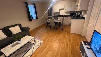 A compact living space with a sofa, dining table, and kitchenette.