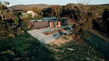 Una propiedad rural con una casa grande, un garaje independiente y un patio cercado.
