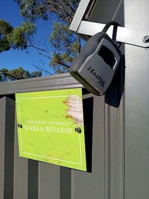 A metal gate with a padlock and a sign indicating 'Park Street - Entrance P Kiara & Reyansh'.